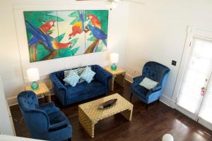基韦斯特Duval House的客厅配有2把蓝色椅子和绘画作品