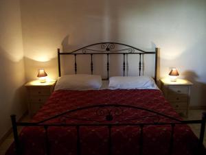 法萨诺Agriturismo Locanda Ventura的一间卧室配有一张带两盏灯的床,位于两个梳妆台上