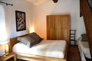 Entrechaux达纳斯旅馆的一间卧室配有一张床和一扇木门