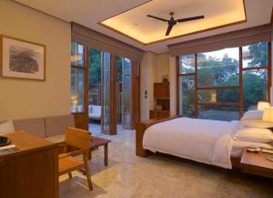重庆重庆柏联酒店的一间卧室配有一张床和一张书桌,另一间卧室配有窗户。