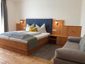 巴特布卢毛加尼兰德弗洛里安酒店的一间卧室配有一张大床和一张沙发