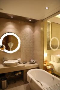 古尔冈泰姬陵市中心古鲁格兰姆酒店的带浴缸、水槽和床的浴室