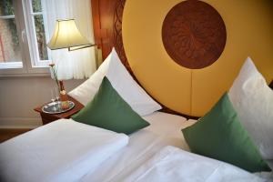 埃施韦格蓬维瑟拉别墅酒店的酒店的客房 - 带绿色和白色枕头的床