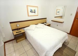 尤西德福拉Solar Flat Hotel的卧室配有一张白色的大床和床头柜。