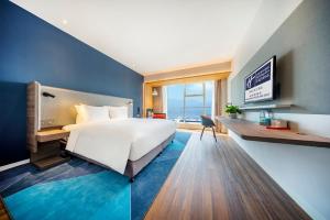 杭州杭州西湖东智选假日酒店的卧室配有一张白色大床和一张书桌