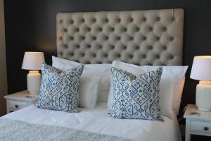 克尼斯纳Waterfront - Knysna Quays Accommodation的一间卧室配有一张带蓝白色枕头的大床