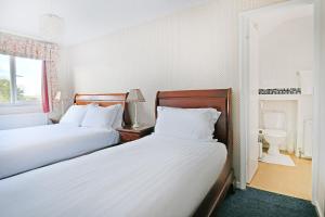 埃文河畔斯特拉特福弗吉尼亚旅馆的一间带两张床的卧室和一间带水槽的浴室
