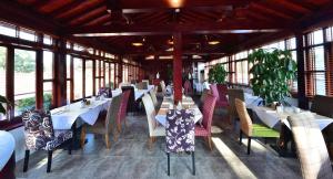 北京景山花园酒店的餐厅设有白色的桌椅和窗户。