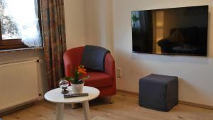 迪布利希Hotel-garni-Kachelburg的客厅配有红色椅子和桌子