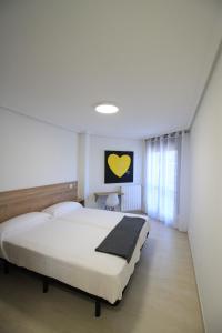 诺哈Apartamentos Gran Socaire de Noja的卧室设有一张白色大床和一扇窗户。