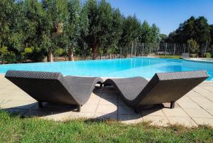 SollacaroRésidence de Filitosa - Le Torréen的两把藤椅坐在游泳池前