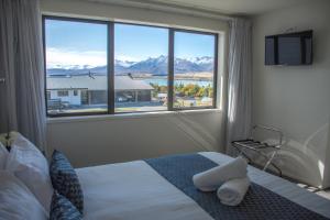 特卡波湖Tekapo Luxury Apartments的一间卧室设有一张床和一个大窗户