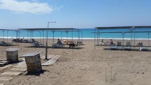 基兹洛特Hotel Schönberg的海滩上设有桌椅,大海上设有沙滩