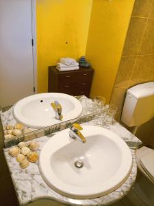 拉戈斯金塔多斯卡拉克丝酒店的一间带两个盥洗盆和卫生间的浴室