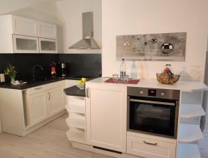 BielatalFerienwohnung Bastei的厨房配有白色橱柜和烤箱。