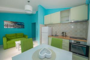 MuoApartments Biskupović的厨房拥有蓝色的墙壁,配有桌子和沙发
