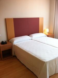 拉斯·罗萨斯·德·马德里塔尔特索斯公寓式酒店的一间卧室设有两张床和两个床头柜
