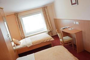 马里博尔普莱贡多拉宾馆的客房设有两张床、一张桌子和一个窗户。