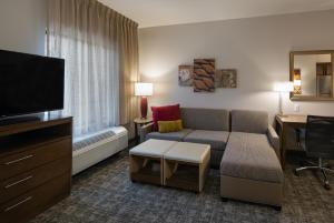 凤凰城Staybridge Suites - Phoenix – Biltmore Area, an IHG Hotel的带沙发和平面电视的客厅