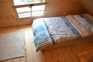 米库洛夫Chata U lomu的木制客房的一张床位,设有窗户