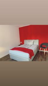 林根Stadtvilla Lingen的一间卧室配有一张红色墙壁的床