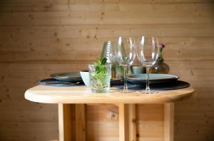 奥斯特韦克Kampinastaete, hippe cottages midden in natuurgebied de Kampina Oisterwijk的一张桌子,上面有三杯酒和盘子