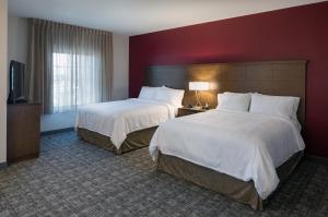 凤凰城Staybridge Suites - Phoenix – Biltmore Area, an IHG Hotel的酒店客房设有两张床和一台平面电视。