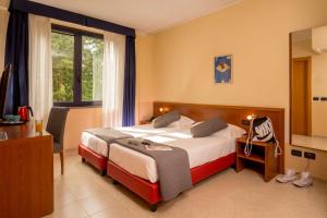 罗马贝斯特韦斯特布鲁罗马酒店的配有一张床、一张书桌和一扇窗户的酒店客房