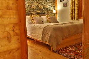 勒沙布勒玛瓦博木屋的一间卧室设有一张床和石墙