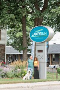 底特律莱克斯Lakes Inn的男人和女人站在狗的标志旁