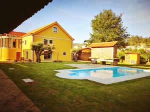 NogueiraCasas do Prazo - Turismo Rural的一个带游泳池和房子的后院