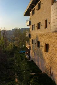 佛雷亚Austria Luxury Apartments, Faraya的一面是一栋砖砌建筑,旁边设有阳台