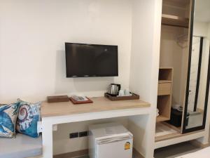纳通市Stay Inn Nathon Samui的一间设有一张桌子的房间,墙上有一台电视机