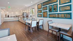 伍德兰希尔斯Best Western Woodland Hills的用餐室配有桌椅和壁画