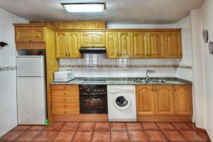 贝纳斯克Apartamentos Petronilla的厨房配有木制橱柜和洗衣机。