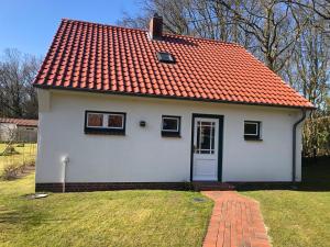 威克奥夫弗尔Haus 1的一座白色的小房子,拥有橙色的屋顶