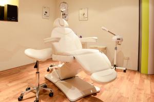 奥尔登扎尔赫特兰德胡伊斯酒店的牙医检查室,配有白色牙科椅和椅子
