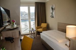 科布伦茨Hotel Morjan的酒店客房设有一张床和一个大窗户