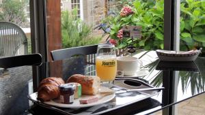 佩罗斯-吉雷克莱斯斯特恩思斯涛特尔酒店的盘子上放着一杯橙汁和面包