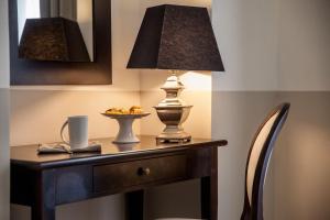 阿拉西奥丽都酒店的一张桌子,上面有台灯和一盘食物