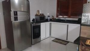 马拉戈日Maragogi Chalé Antunes的厨房配有不锈钢冰箱和白色橱柜
