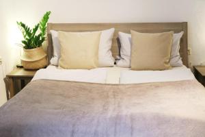 鲁斯特斯特凡科赫住宿加早餐旅馆的一张带白色床单和枕头的床以及植物
