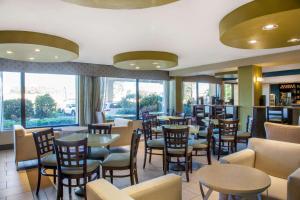奥克兰奥克兰机场体育馆拉金塔旅馆及套房的餐厅设有桌椅和窗户。
