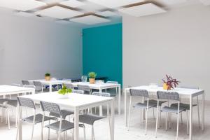格但斯克Hostel Montessori的一间设有白色桌椅和蓝色墙壁的客房