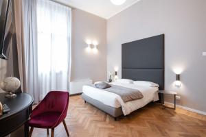 威尼斯Hotel Palazzo Martinelli Dolfin的一间卧室配有一张大床和一张红色椅子