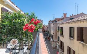 威尼斯Grifoni Boutique Hotel的城市街道上种有红色鲜花的阳台