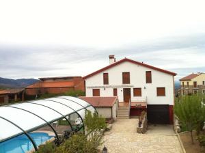 La HoyaRefugio La Covatilla I,II,III y IV的一座白色的房子,前面设有一个游泳池