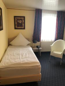 奥尔珀阿卜思酒店的卧室配有床、椅子和窗户。