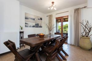 达西亚Adonis Villa的一间带木桌和椅子的用餐室