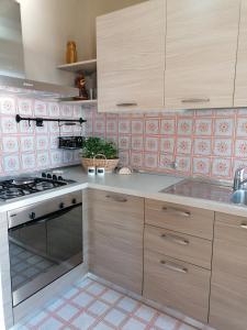 圣文森特Casa vista Saint Vincent accanto alle Terme的厨房配有木制橱柜和炉灶烤箱。